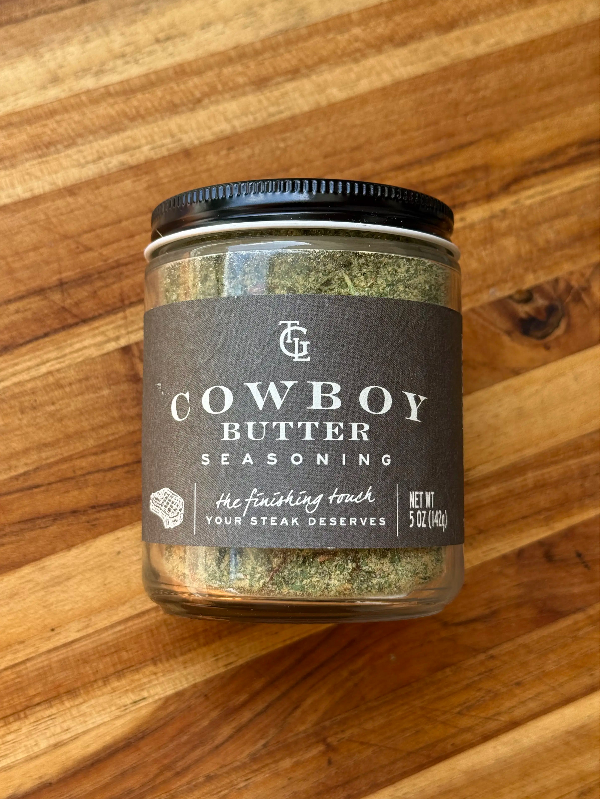 Jar of TGL cowboy butter seasoning on a wooden surface